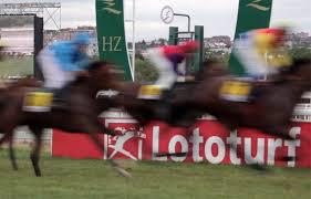Caballos pasando delante del cartel de Lototurf | Foto: Hipódromo de la Zarzuela