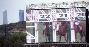 Pantalla del hipódromo con los rascacielos de Madrid de fondo | Foto: Hipódromo de la Zarzuela