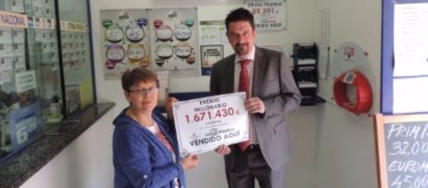 Foto: Imagen de la lotera recibiendo el cartel de haber repartido el premio