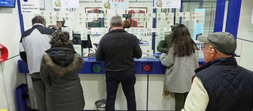 Varios clientes compran en una administración de lotería.