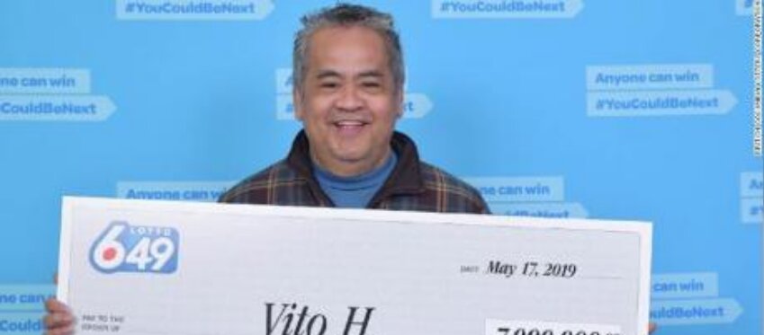 El agraciado posa con su cheque de 7 millones de dólares canadienses.