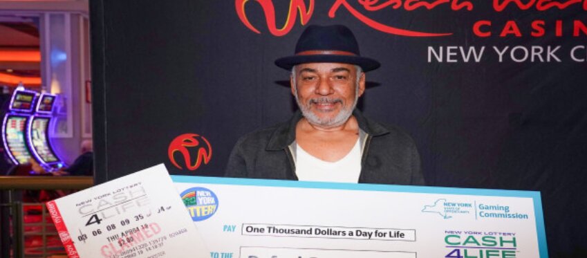 El agraciado posa con su cheque ganador.