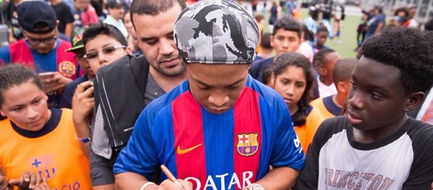 Ronaldinho firma autógrafos a un grupo de aficionados. Foto: Twitter.
