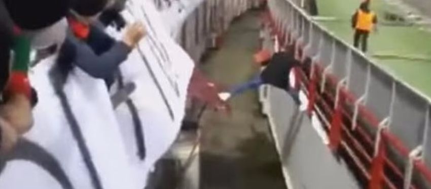El aficionado ruso tiró de ingenio para superar el foso del estadio en su huida. Foto: Youtube.